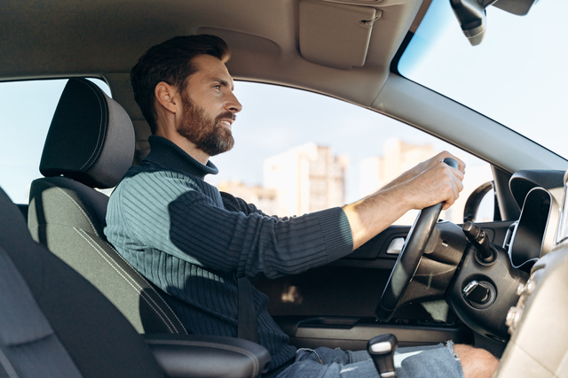 image of man driving inside car depicting how insurance companies rate drivers in ontario