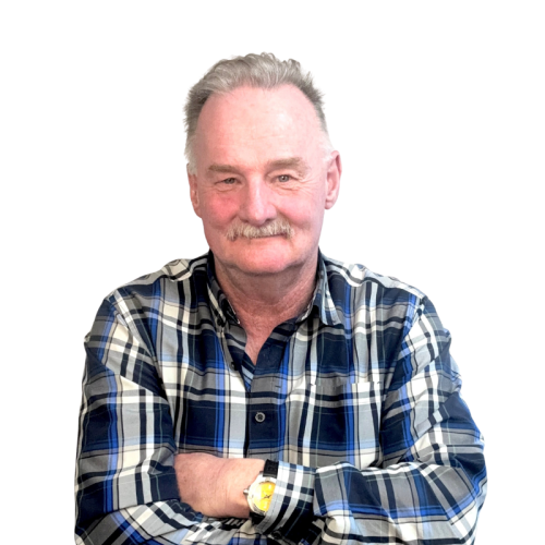Tod McGoey, the president of McGoey insurance standing with a smile and his arms crossed in business attire and a white background.